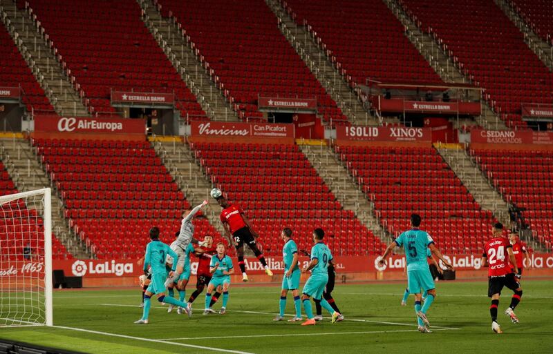 Marc-Andre ter Stegen punches the ball away in front of Mallorca's Iddrisu Baba. Reuters