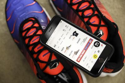 A phone displaying the app of Nice is arranged for a photograph next to a pair of sneakers at the office of the online sneaker trading platform in Beijing, China, on Wednesday, Sept. 25, 2019. Across China, more than 10 million monthly active users frequent online-resale apps for sneakers, such as Poizon, Nice and DoNew, according to Chinese data-mining company QuestMobile. While many products suffer from the effects of the trade war, pairs of collectible sneakers are flying off the shelves, and that's attracting the attention of U.S. sneaker exchanges like StockX and GOAT. Photographer: Qilai Shen/Bloomberg