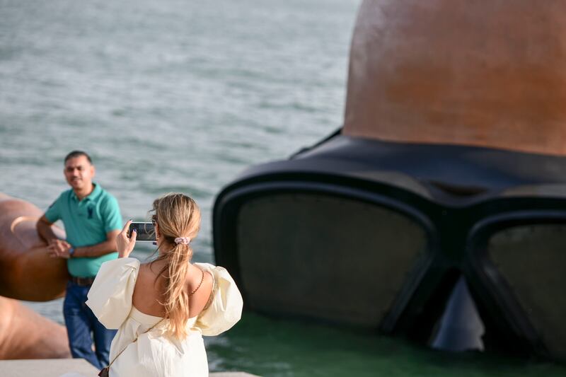 Visitors take photos near the giant sculpture at Yas Bay Waterfront during Eid Al Fitr in Abu Dhabi. 
