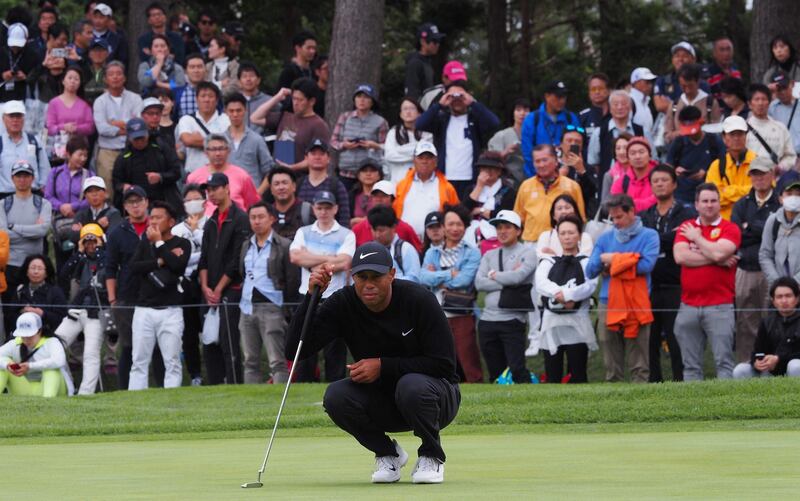 Tiger Woods lines up a putt on the 5th hole. AFP