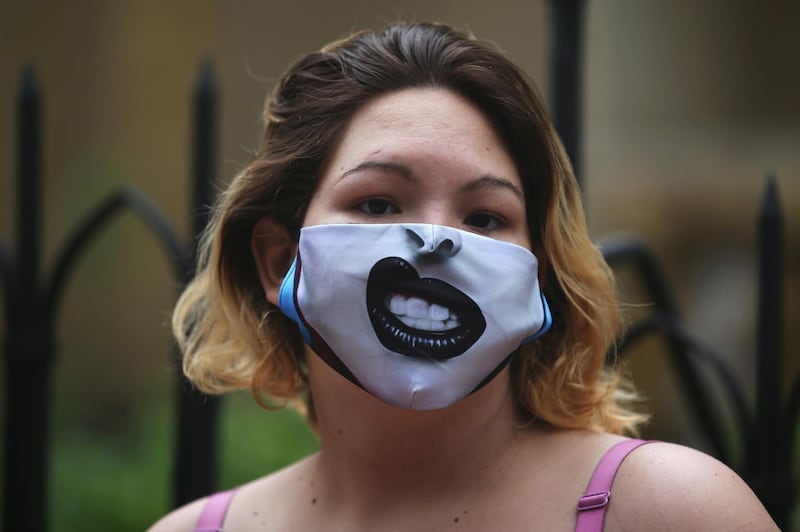 A Venezuelan migrant wearing a face mask is seen standing in line to receive food aid in Bogota, Colombia. Reuters