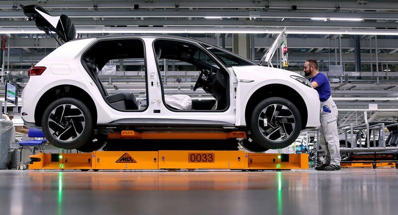 (FILES) In this file photo taken on February 25, 2020 an employee of German car maker Volkswagen (VW) works on an assembly line to produce models of the Volkswagen electric car, the ID.3 model, on a assembly line at the Volkswagen car factory in Zwickau, eastern Germany. The transition to electric cars could affect by 2030 up to a third of jobs in Germany's automotive industry, a pillar of the national economy, in automakers and subcontractors where conventional engines still dominate, according to a study published on May 6, 2021. / AFP / RONNY HARTMANN
