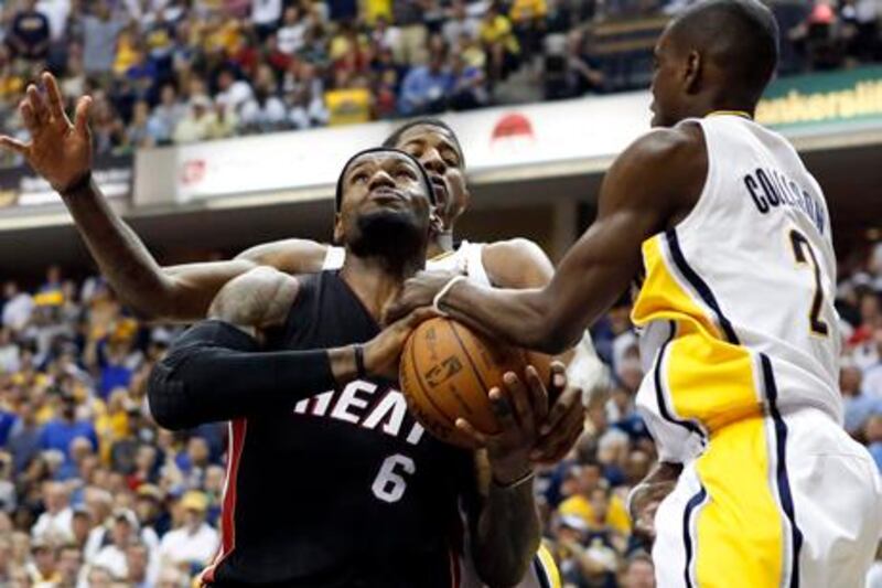 epa03228019 Miami Heat forward LeBron James, left, is tangled up under the basket with Indiana Pacers guard-forward Paul George, middle, and teammate Darren Collison, right, in the second half of game 4 of the Eastern Conference Semifinals. Indiana Pacers defeat Miami Heat, 101-93 to take a 3-1 lead in the series. NBA playoff game between the Miami Heat and Indiana Pacers at Bankers Life Fieldhouse in Indianapolis, Indiana, USA, 20 May 2012.  EPA/MATTHEW Z. DIAL Corbis Out