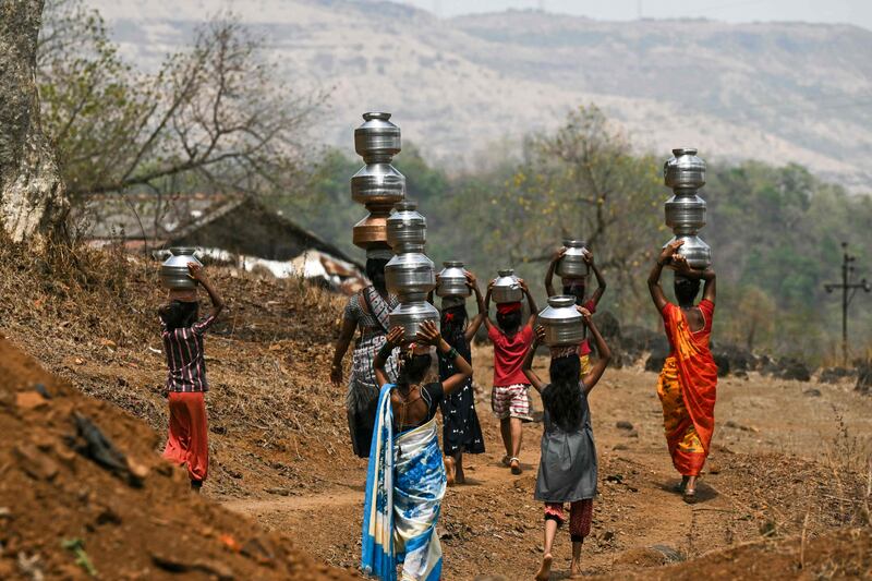 Villagers carry water pots in Shahapur district of India's Maharashtra state as a heatwave continues. AFP