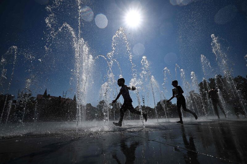 Children cool off as they run through a public fountain in Colmar, eastern France. AFP