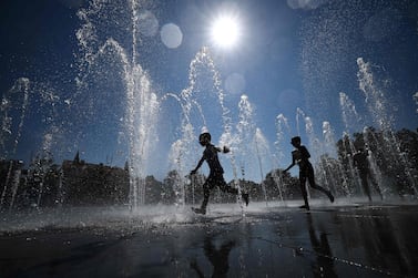 Children cool off as they run through a public fountain in Colmar, eastern France, on August 21, 2023, as France experiences a late summer heatwave.  In the "hottest" episode of summer 2023 in France Météo-France has warned of an "intense and lasting" heat wave with 50 out of 96 departments in mainland France placed on orange vigilance saying "we could reach temperature levels never before seen in France".  The highest temperature ever recorded in France is 46 degrees in Verargues, in Herault, on June 28, 2019.  (Photo by SEBASTIEN BOZON  /  AFP)
