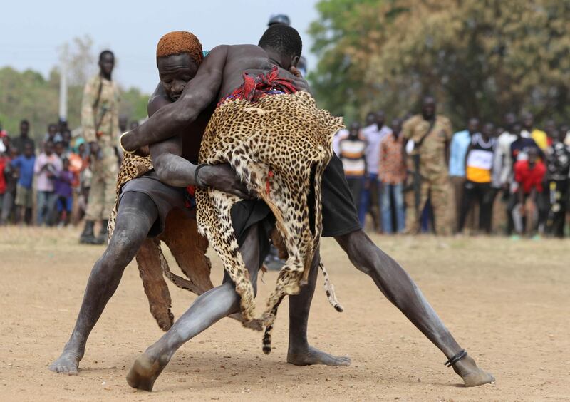 South Sudan's traditional wrestler Dengic Parrach (R) from Yirol is tackled by Ekuach Ladu from Terekeka dressed in a leopard skin as they compete in a peace match during national championships in Juba, South Sudan February 1, 2020. Picture taken February 1, 2020. REUTERS/Samir Bol