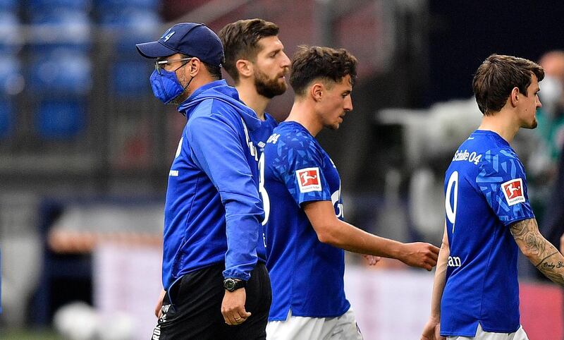 Schalke's head coach David Wagner, left, passes his players on the pitch after losing the Bundesliga match to Augsburg in Gelsenkirchen 3-0. AFP