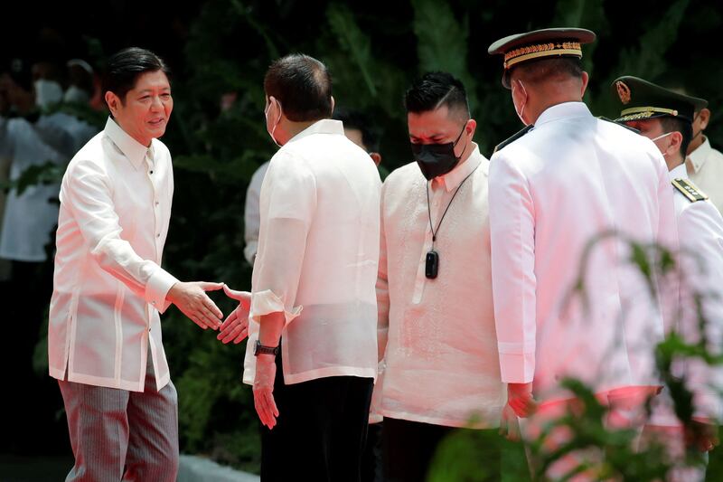 Departing Philippine President Rodrigo Duterte, second from left, shakes hands with incoming President Ferdinand Marcos Jr during the inauguration ceremony for Mr Marcos in Manila. AFP