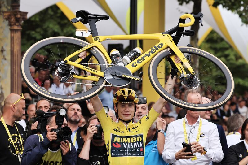 Jonas Vingegaard raises his bike in celebration after winning the Tour de France.  EPA 