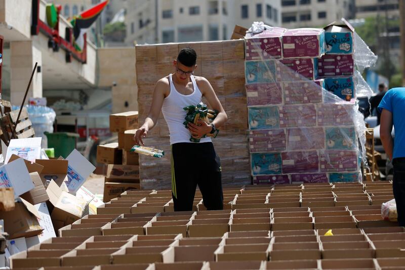 A Palestinian packs boxes with food that will be distributed to poor Palestinian families ahead oof the hoy month of Ramadan, in Nablus, West Bank. AP Photo