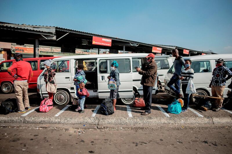 Commuters adhere to physical distancing measures while queueing at the Germiston Taxi Rank, near Johannesburg, South Africa. AFP