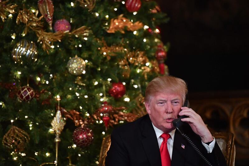 US President Donald J. Trump participates in NORAD Santa Tracker phone calls at the Mar-a-Lago resort in Palm Beach, Florida on December 24, 2017. 
"NORAD Tracks Santa" is an annual Christmas-themed entertainment program, which has existed since 1955, produced under the auspices of the North American Aerospace Defense Command. / AFP PHOTO / Nicholas Kamm