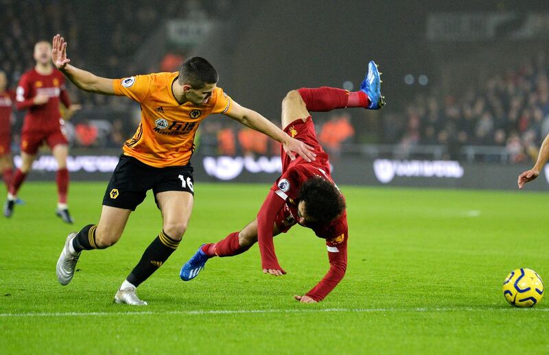 Liverpool's Mohamed Salah, right, is tackled by Conor Coady at the Molineux Stadium. EPA