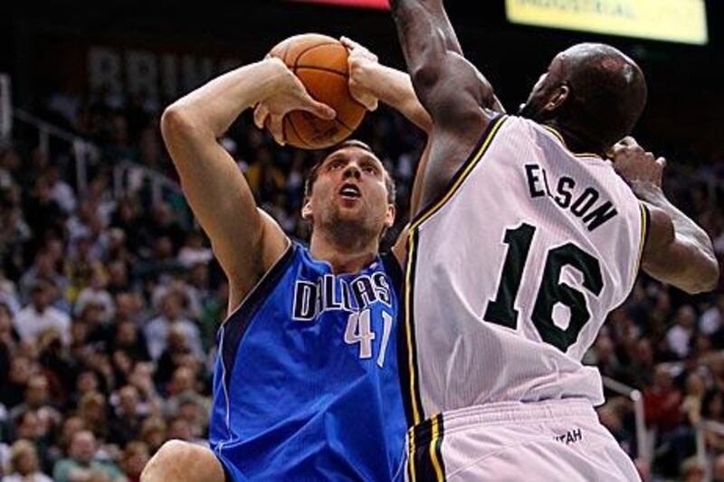 The Dallas Mavericks power forward Dirk Nowitzki, left, attempts to score against Utah Jazz centre Francisco Elson.