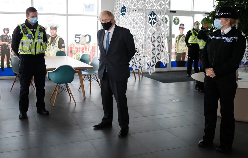 Boris Johnson meets police officers who deal with Covid rule enforcement, during a visit to South Wales Police headquarters in Bridgend, Wales. AP Photo