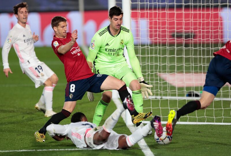 Real goalkeeper Thibaut Courtois watches the ball go out of play under pressure from Osasuna's Darko Brasanac. AP