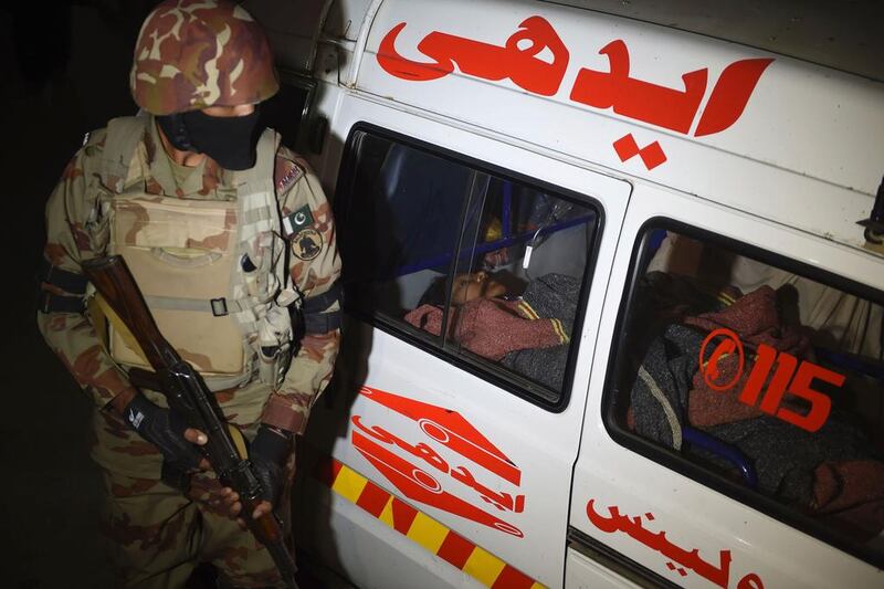 A Pakistani paramilitary soldier stands guard next to injured blast victim awaiting treatment in an ambulance at a hospital in the Hub district, some 40 kilometers from Karachi, on November 12, 2016.  At least 43 people died and scores of others were injured when a bomb exploded at a remote Sufi shrine in southern Pakistan's restive Balochistan province on November 12, officials said. The blast hit a crowd of worshippers participating in a ceremony at the shrine of Sufi saint Shah Noorani in Khuzdar district, some 760 kilometres south of provincial capital Quetta. / AFP / ASIF HASSAN