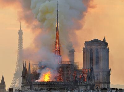FILE - In this file photo dated Monday, April 15, 2019, with the Eiffel Tower behind, left, flames and smoke rise from the blaze at Notre Dame Cathedral in Paris that destroyed its spire and its roof but spared its twin medieval bell towers, and prompted a frantic rescue effort to save its most precious artefacts.  The recent devastating Notre Dame fire in Paris was a warning bell that all of Europe needs to hear, since so many monuments and palaces across the continent are in need of better upkeep according to European officials.  â€œWe are so used to our outstanding cultural heritage in Europe that we tend to forget that it needs constant care and attention,â€ Tibor Navracsics, the European Unionâ€™s top culture official, told The Associated Press.  (AP Photo/Thierry Mallet, FILE)