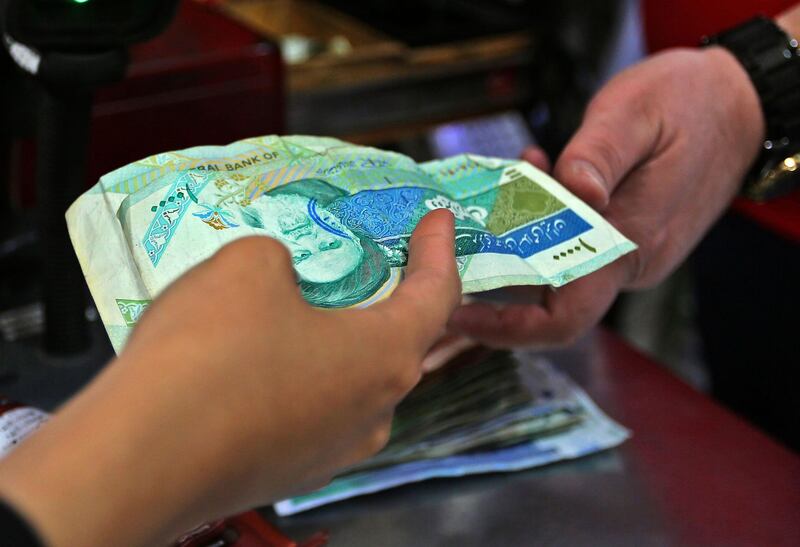 An Iranian customer pays with local currency for her purchase at a shop in the Islamic republic's capital  Tehran, on April 24, 2019. Iranians, already hard hit by punishing US economic sanctions, are bracing for more pain after Washington abolished waivers for some countries which had allowed them to buy oil from Iran. / AFP / ATTA KENARE
