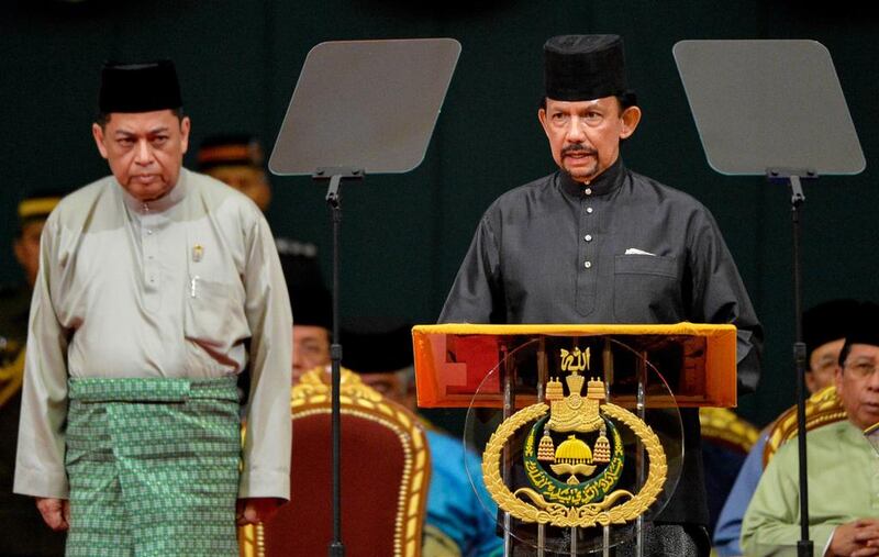 Sultan of Brunei Hassanal Bolkiah (right) delivers a speech during the official opening of the Majlis Ilmu 2013 in Bandar Seri Begawan. Also yesterday, the sultan announced the phased introduction of tough Islamic punishments including death by stoning for crimes such as adultery, in the monarchy's latest step towards conservatism. Dean Kassim / AFP

