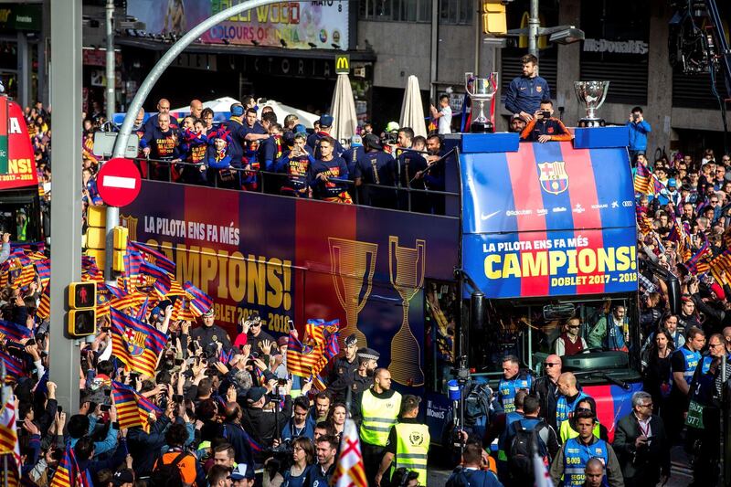 Thousands of fans line the streets as the Barcelona players parade their trophies. Enric Fontcuberta / EPA