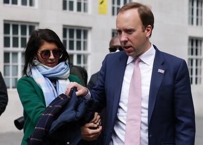 Matt Hancock hands his coat to his aide Gina Coladangelo in May this year. Reuters