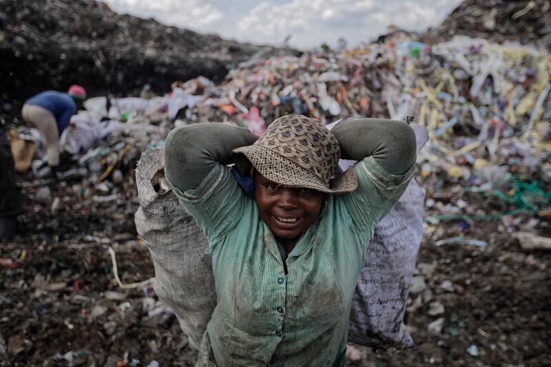A woman carries a sack of recyclable materials at the dump in the Dandora slum of Nairobi, Kenya. AP Photo