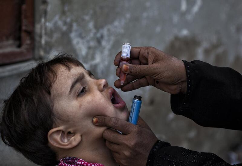 A health worker administers polio drops to a child in Karachi. Asim Hafeez/The National