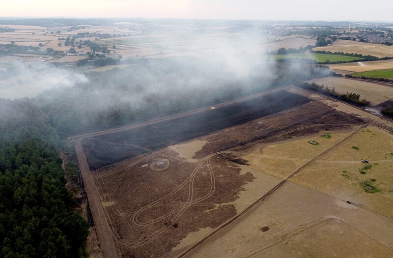 Burnt woodland is seen as smoke rises from the trees following a fire in Blidworth. Getty Images