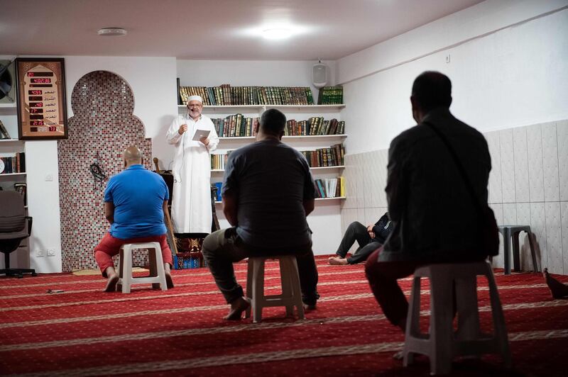Imam Abderrahmane Ghoul speaks to his social distanced worshippers. AFP