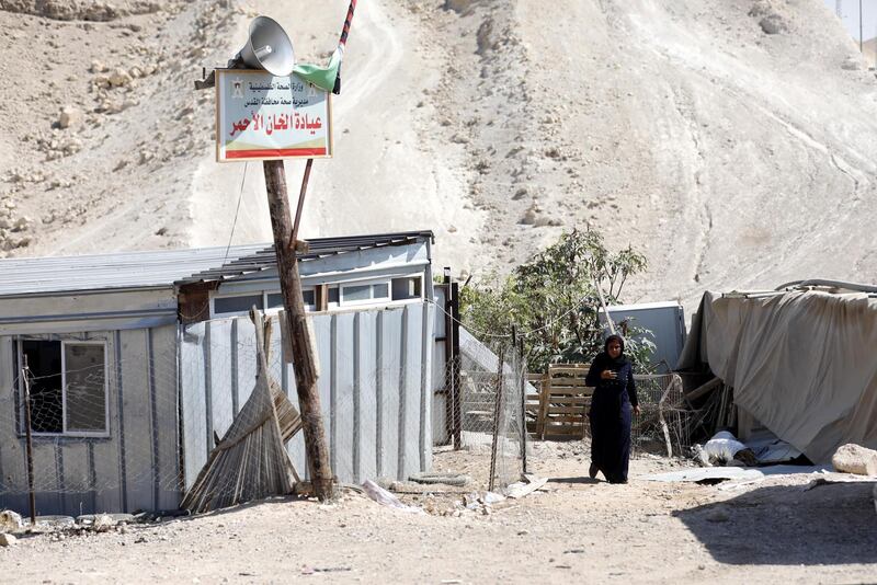 A Palestinian Bedouin woman walks near a clinic in Khan al-Ahmar, located between the West Bank city of Jericho and Jerusalem near the Israeli settlement of Maale Adumim. Khan al-Ahmar is a Bedouin community where some 180 people live in shacks, that Israeli authorities claim were built without obtaining permits. EPA