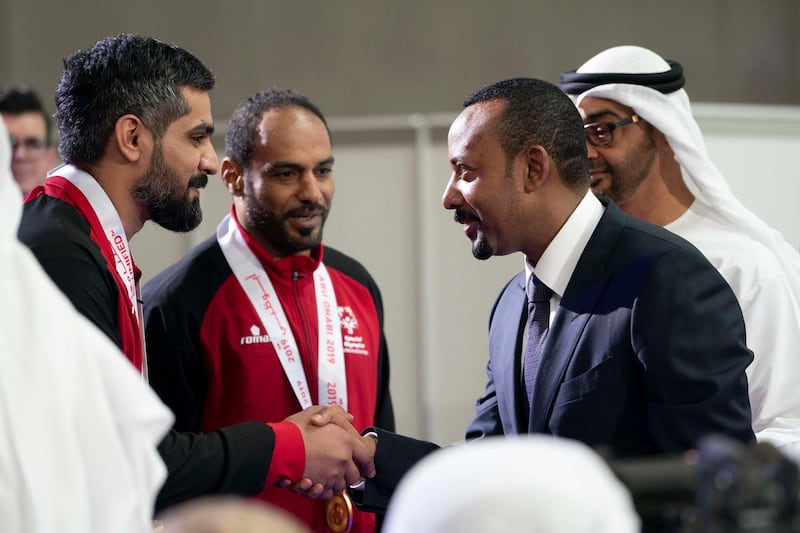 ABU DHABI, UNITED ARAB EMIRATES - March 20, 2019: HE Abiy Ahmed, Prime Minister of Ethiopia (R) greets  an athlete during the Special Olympics World Games Abu Dhabi 2019 at Abu Dhabi National Exhibition Centre. Seen HH Sheikh Mohamed bin Zayed Al Nahyan, Crown Prince of Abu Dhabi and Deputy Supreme Commander of the UAE Armed Forces (Back R).

( Mohamed Al Hammadi / Ministry of Presidential Affairs )
---