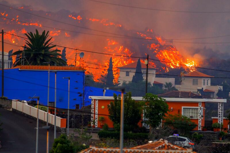 Lava flows behind houses following the eruption of a volcano on the Canary Island of La Palma, in Spain. The eruption forced the relocation of 5,000 people. Cumbre Vieja had been dormant for 50 years. Photo: Reuters