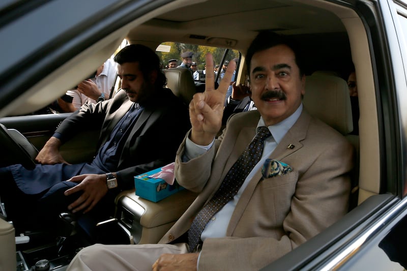 Former prime minister Yousuf Raza Gilani flashes victory signs as he arrives. AP