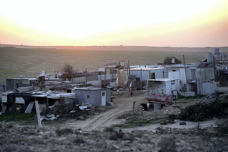 A view showing homes of corrugated tin , networks of pipes providing water and solar panels at night in the  unrecognized village of al-Poraa and others near the city of Arad in the Negev Desert on February 24,2018.A plan is being discussed to build a giant phosphate mine which thousands of Bedouins living in the area and also people in Arad  fear could not only risk their health. Many Bedouins expressed a fear that the new mine could  evict them from the land they have  lived for generations .(Photo by Heidi Levine for The National).
