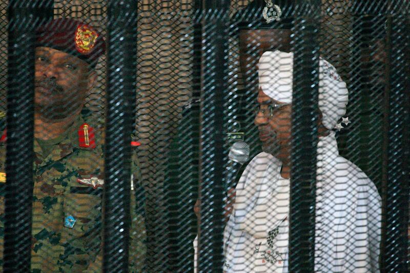(FILES) In this file photo taken on August 19, 2019, Sudan's deposed military ruler Omar al-Bashir stands in a defendant's cage during the opening of his corruption trial in Khartoum. The Arab Spring uprisings are nearly a decade-old and moribund but protests in Sudan and three other new countries last year revealed that the spirit of the revolts that lit up 2011 is still alive. The countries swept up by the latest revolts had initially stood on the sidelines as a contagion of uprisings gripped countries in the Middle East and North Africa in 2011. But in 2019 they led calls for an end to the same regional economic precariousness, corruption, and unresponsive governance that fuelled the Arab protests years earlier. / AFP / Ebrahim HAMID
