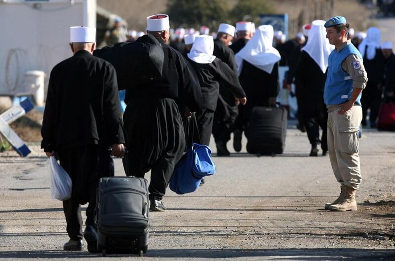 UN soldiers watch Druze men from the Golan heights as they cross to Syria for religious occasion. Atef Safadi / EPA