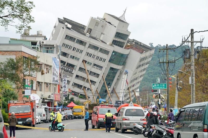 Rescue and emergency workers block off a street where a building came off its foundation, the morning after a 6.4 magnitude quake hit the eastern Taiwanese city of Hualien, on February 7, 2018. Rescue workers scrambled to search for survivors in buildings left tilting precariously on their foundations. Paul Yang / AFP
