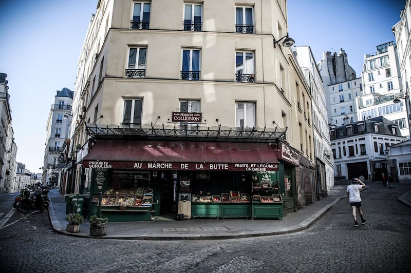 A man passes by the grocery store 'La Maison Collignon', known for appearing as a movie set in the French film 'Amelie' in Paris, France. EPA