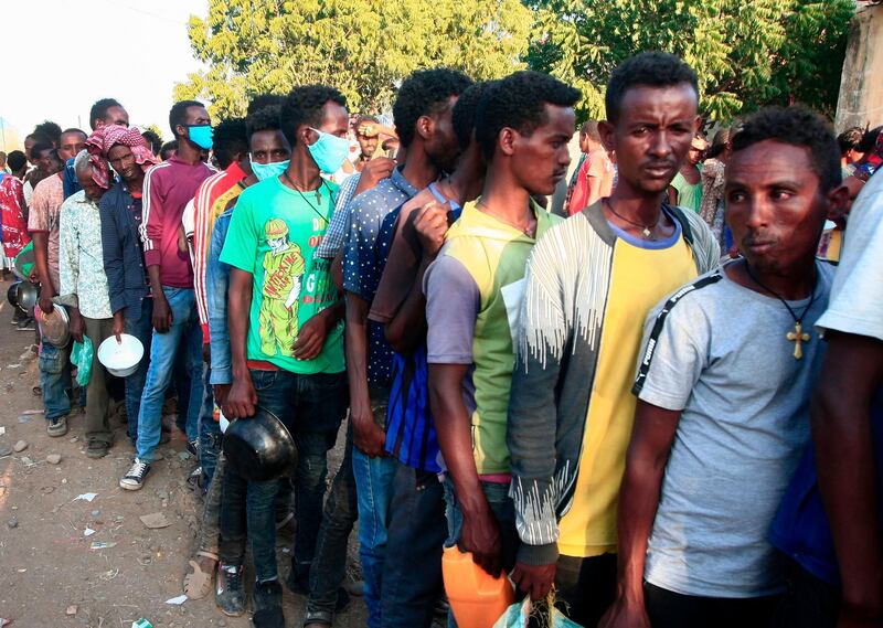 Ethiopian migrants who fled intense fighting in their homeland of Tigray,  wait for their ration of food in the border reception center of Hamdiyet, in the eastern Sudanese state of Kasala, AFP