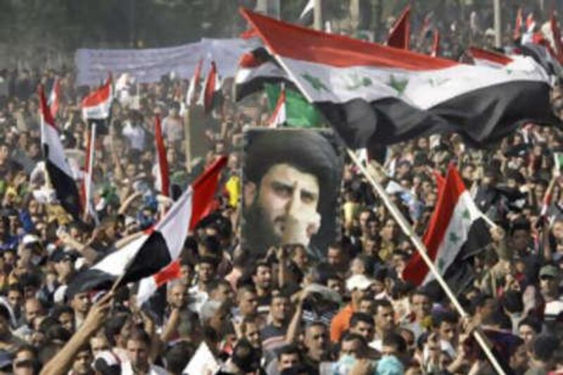 Thousands of followers of Shiite cleric Muqtada al Sadr, pictured in the poster, converge on Firdous Square in central Baghdad, Iraq for a mass prayer to protest a proposed US-Iraqi security pact on  Nov 21 2008.