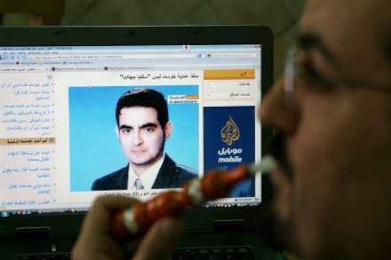 A Jordanian man smokes as he browses a  news website showing the suspected Jordanian suicide bomber Humam Khalil Abu-Mulal al-Balawi, at a coffe shop in Amman, Jordan, Thursday, Jan. 7, 2010. Al-Balawi, who is suspected of detonating the suicide bomb on  December 30, 2009, allegedly duped agents into granting him entry to the CIA base by leading them to think he would help track down al-Qaida's No. 2 leader, Ayman al-Zawahri, officials have said.(AP Photo/Nader Daoud) *** Local Caption ***  AMM103__Jordan_CIA_Afghan_Attack.jpg