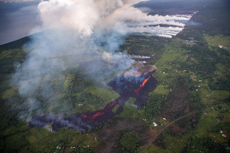 Eruptive activity continuing at fissure 17, as lava from that vent advanced roughly a mile, covering property, mainly pastureland, but is now encroaching upon two major thoroughfares, and a number of homes, in Pahoa, Hawaii on 14 May, 2018. Bruce Omori / EPA