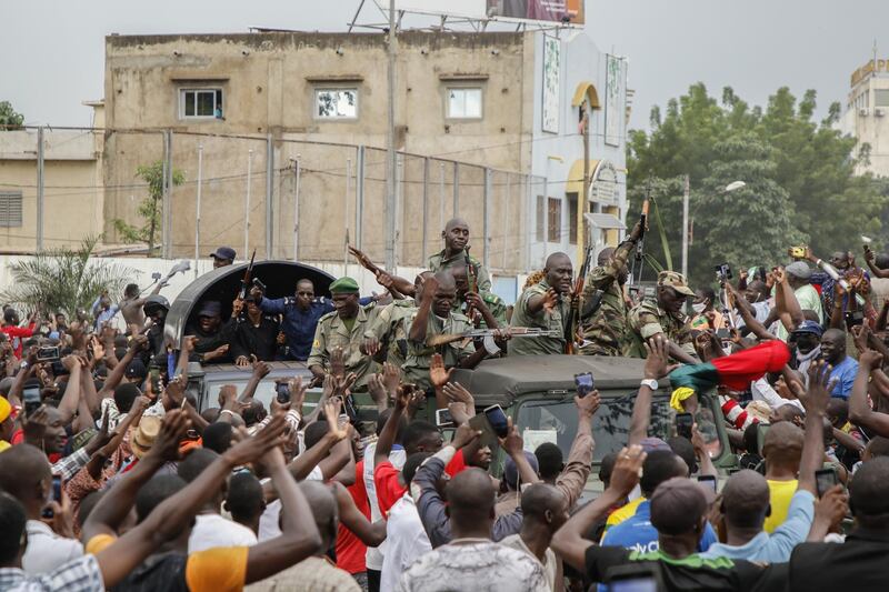 Crowds cheer as soldiers parade in vehicles along the Boulevard de l'Independance in Bamako, Mali. Getty Images