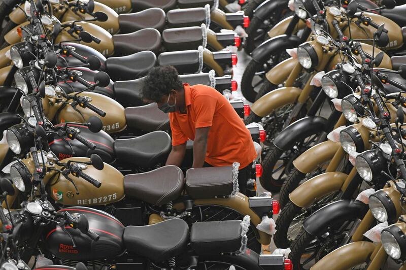 A worker checking on a finished motorcycle at an assembly unit of Royal Enfield motorcycle inside its factory in Oragadam, Tami Nadu.  AFP