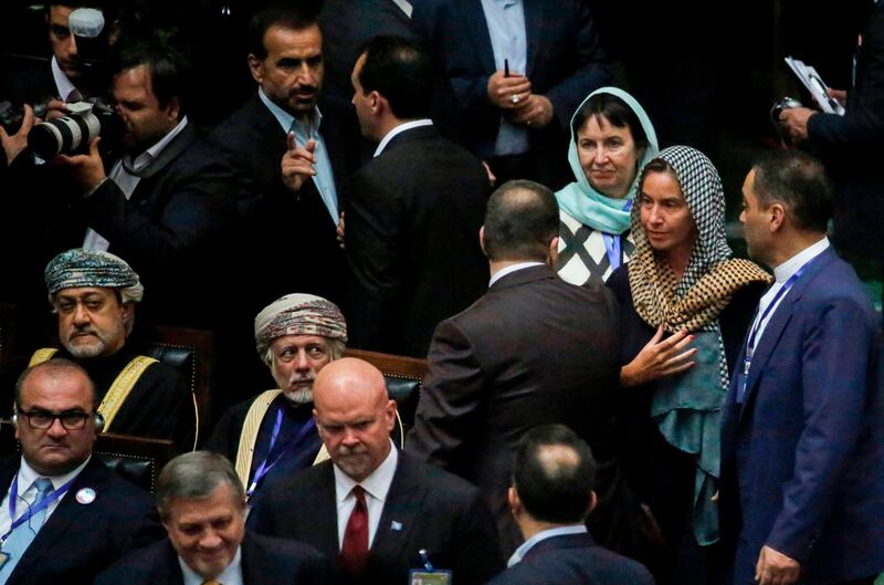 Oman's foreign minister Yusuf bin Alawi-bin Abdullah, centre seated, sits as EU foreign policy chief Federica Mogherini, second right, passes by after the swearing in of Iran's president during an official ceremony before parliament in Tehran. AFP