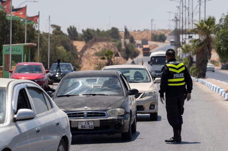 A Jordanian policeman checks cars at a checkpoint at the entrance of Al Ramtha, about 70 kilometres north of Amman, near the Syrian border.  EPA