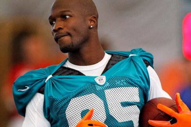 FILE - In this Sunday, July 29, 2012 file photo, Miami Dolphins' Chad Johnson practices during NFL football training camp in Davie, Fla.  Police say Dolphins receiver Chad Johnson has been arrested on a domestic violence charge, accused of head-butting his newlywed wife during an argument in front of their home in Davie, Fla. (AP Photo/Terry Renna, File)