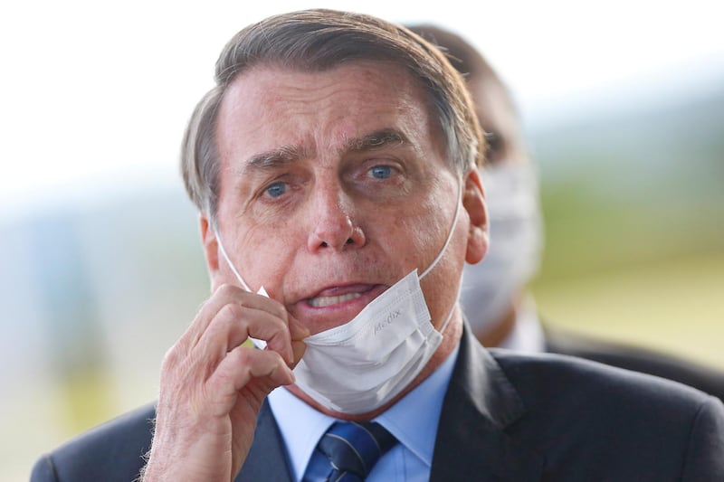 Brazil's President Jair Bolsonaro adjusts his mask as he leaves Alvorada Palace, amid the coronavirus disease outbreak in Brasilia, Brazil. Reuters